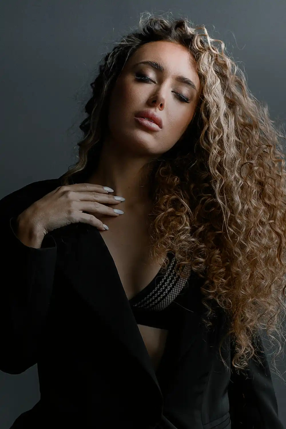 Woman with curly hair in black jacket.